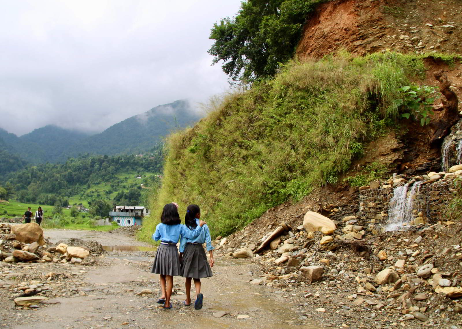 Two girls walking along a path in Nepal