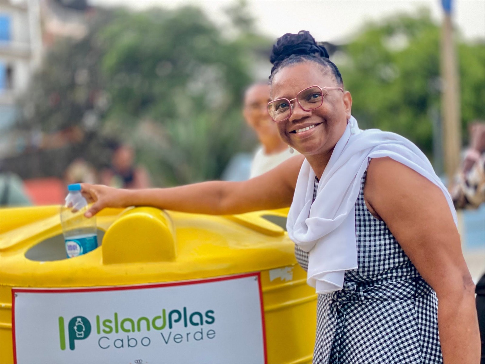 Une habitante du Cap-Vert dépose une bouteille en plastique dans un point de collecte IslandPlas afin de favoriser le recyclage des déchets plastiques.