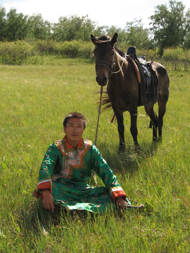A young Mongolian herder with his horse in Xiwu Qi, Inner Mongolia of China. Despite the pressure from mining activities around his land, the herder is still enthusiastic with carrying on herding lifestyle.