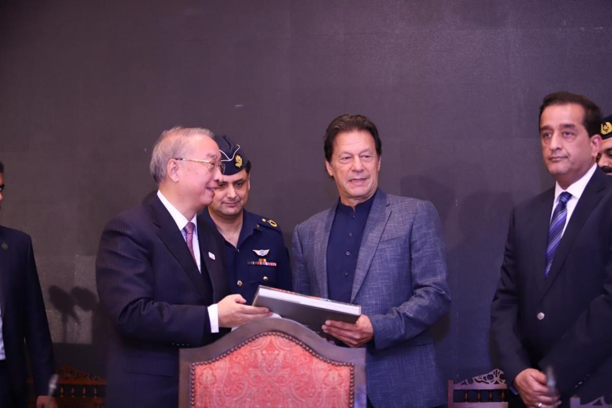 IUCN President Zhang Xinsheng handing over the IUCN Earth Legacies: World Heritage Sites publication to Prime Minister Imran Khan