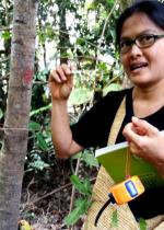 woman with glasses and book in hands talking