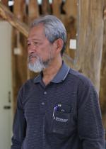 Man with white and grey beard and hands at sides
