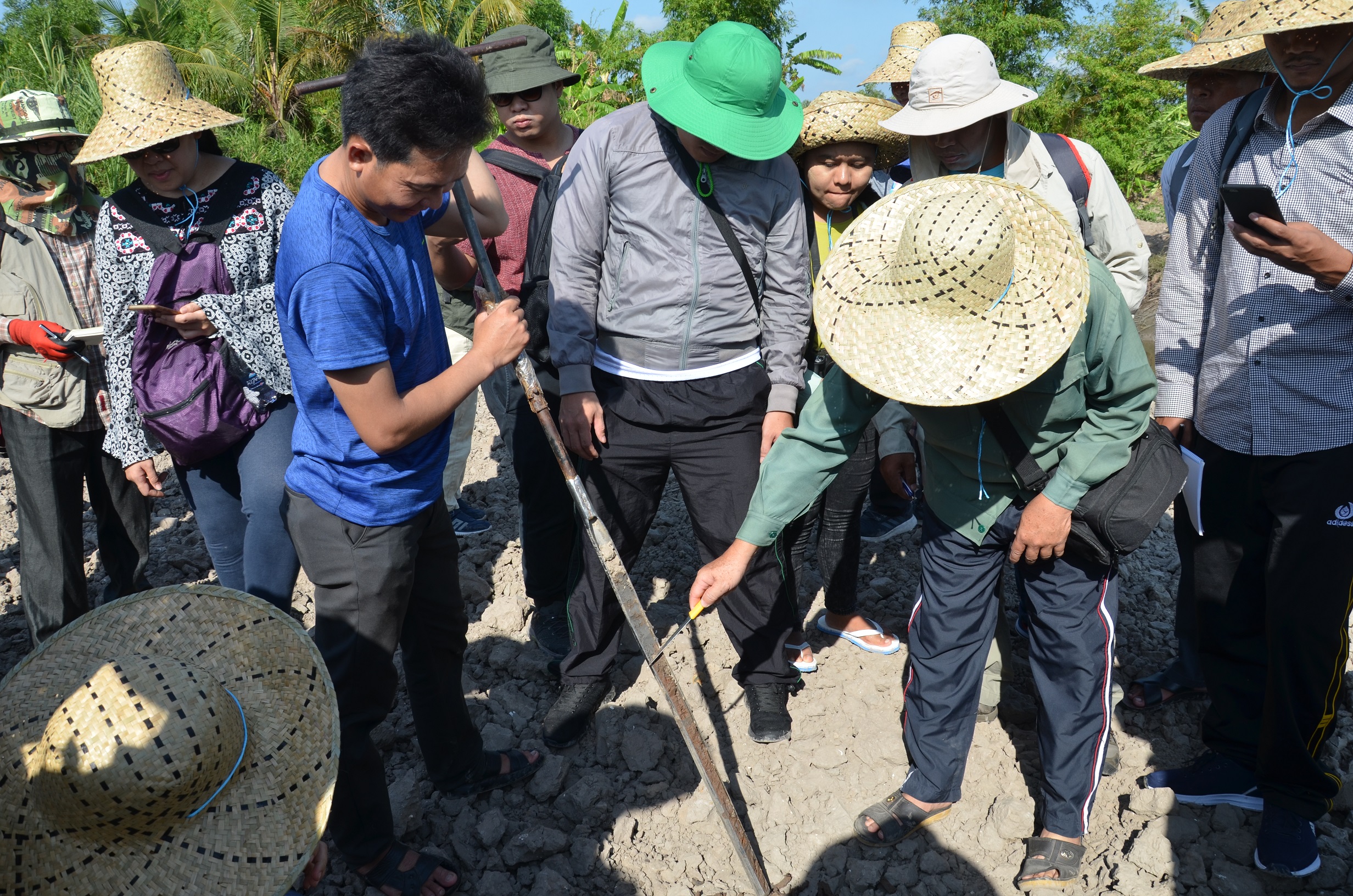 Instructor Dr. Duong Van Ni demonstrates soil sampling and explains how it can be used to gather data on wetlands