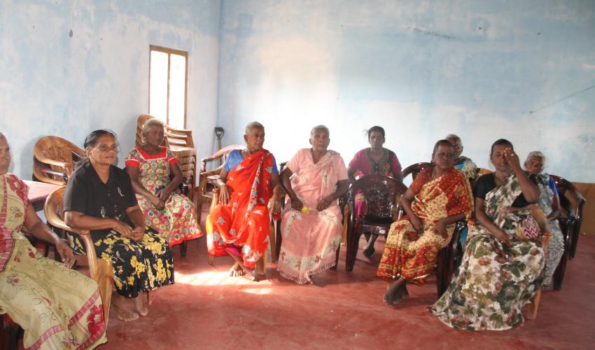 Mary (second from the left) sitting with other community members at a session that aims to raise awareness about climate change
