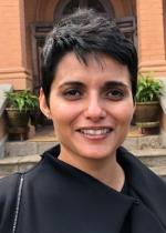 woman short black hair looking at camera, stairs door behind