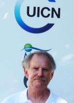 Man with white shirt below IUCN sign