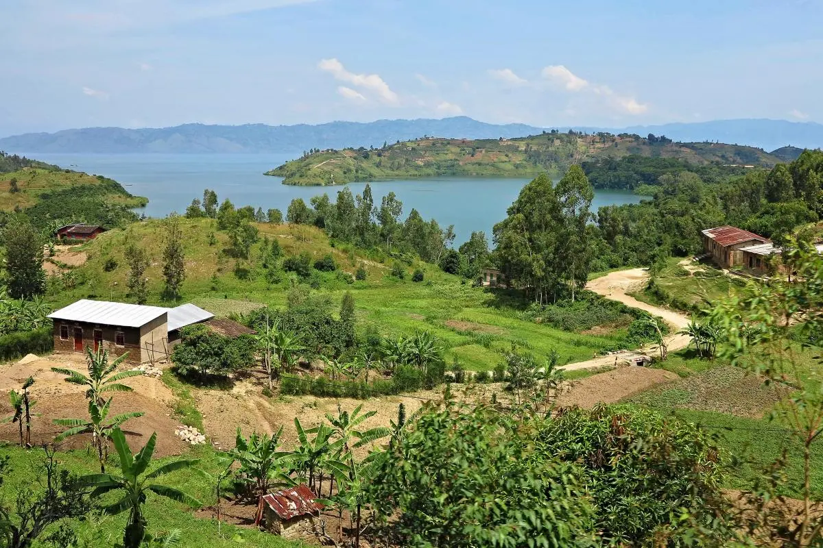 lake in background with agriculture and shacks in foreground