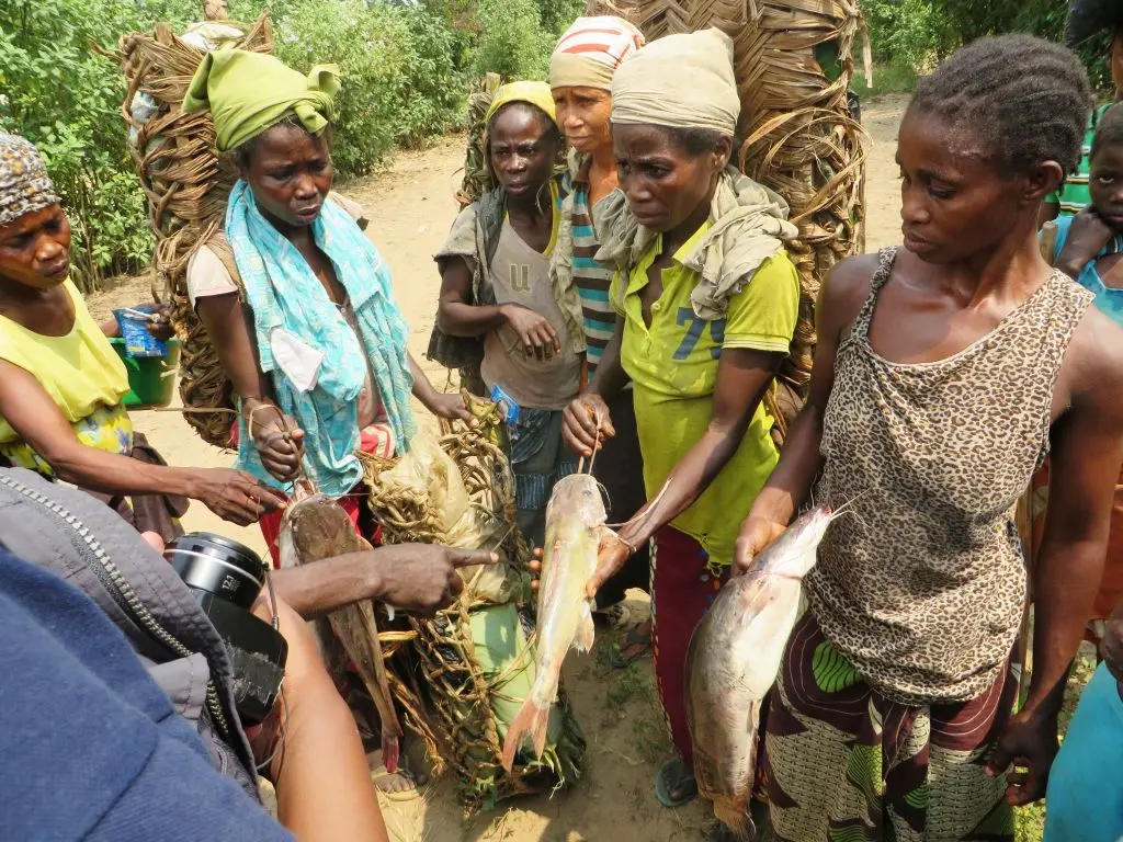 women in group holding fish