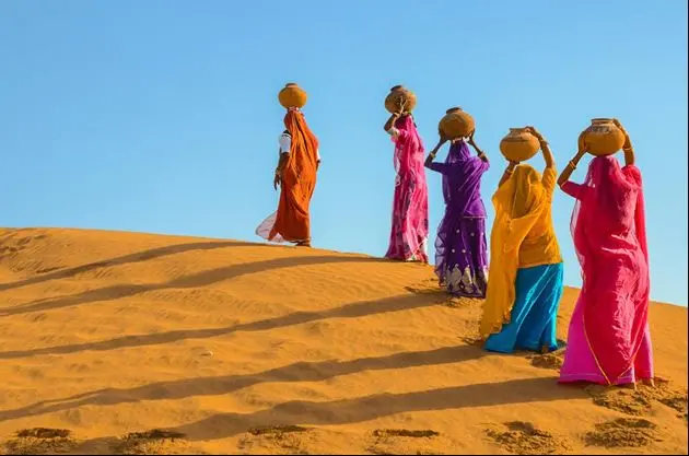 Women carrying water in the desert